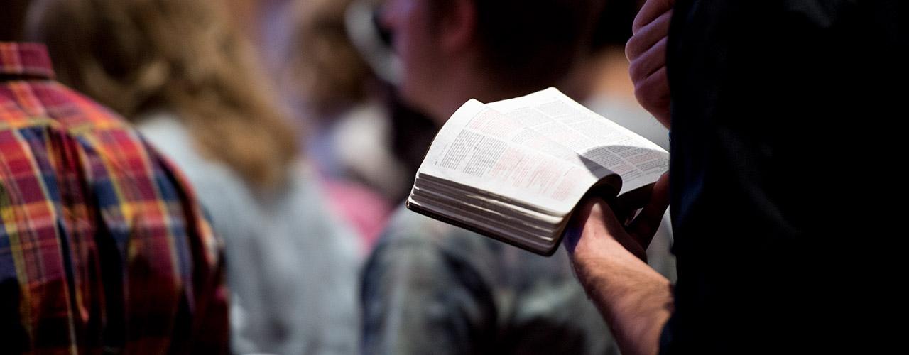 Male student reads from Bible during chapel